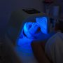 Woman having Ultraviolet LED light facial treatment at beauty salon. Cosmetology. female Face At blue Light Treatment At Beauty Clinic.